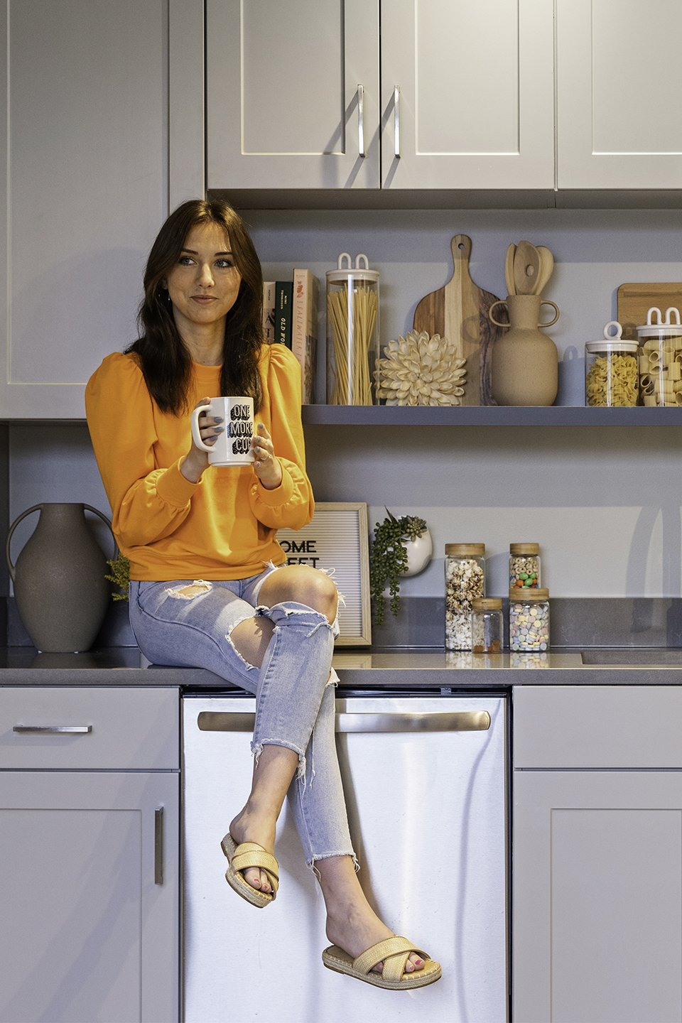 A woman sitting on a kitchen counter