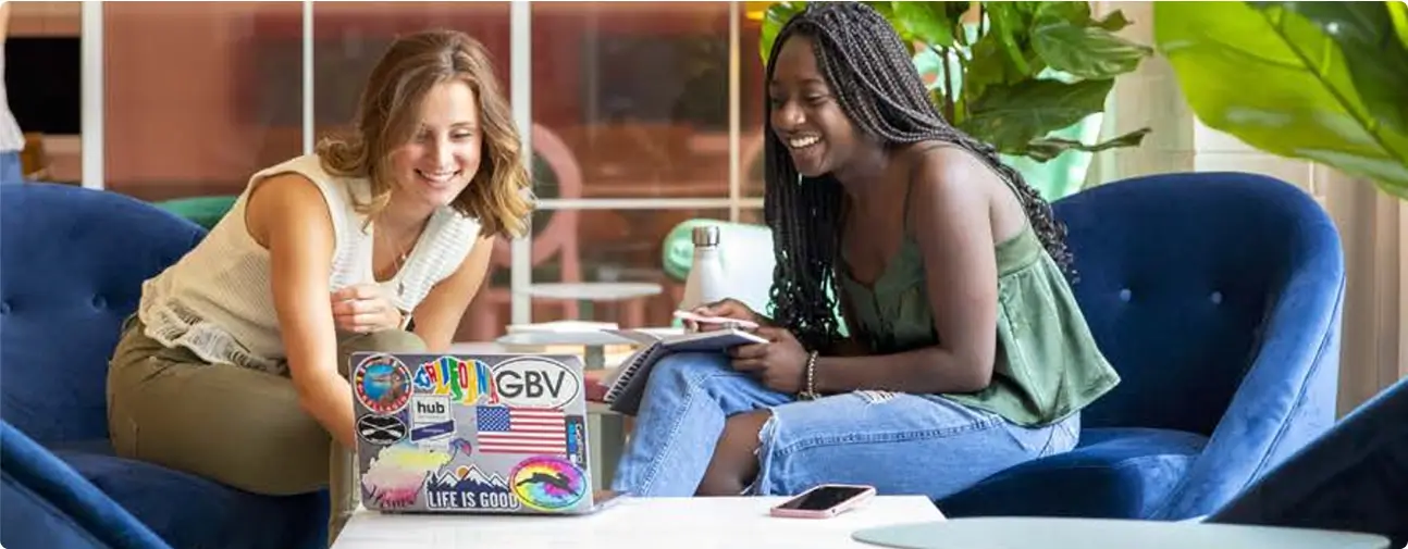 two women using a laptop